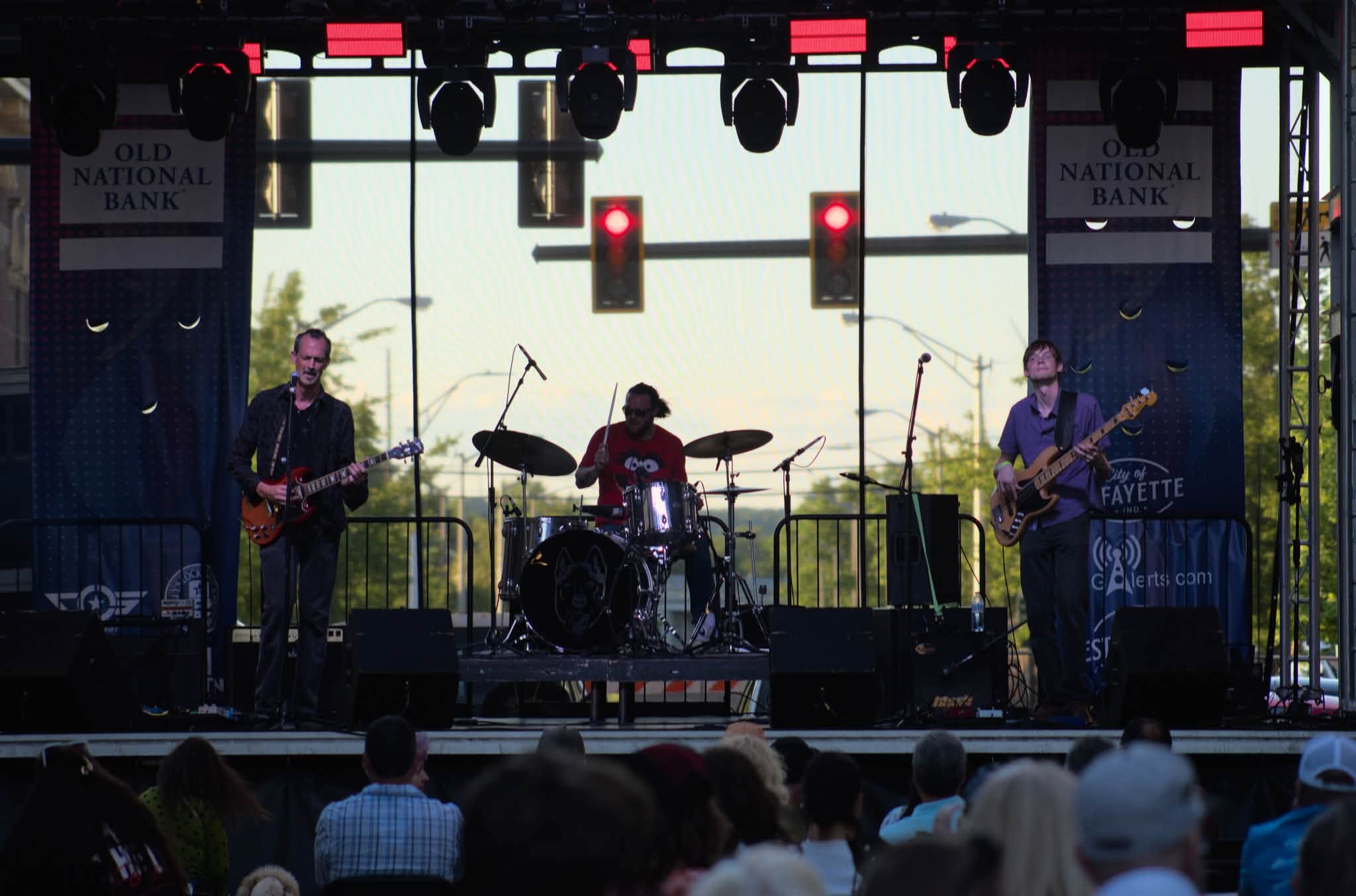 The full band performing live on an outdoor stage